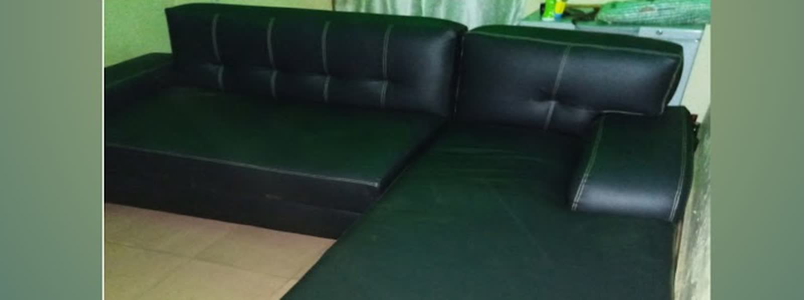 Restored black L-shaped sofa after Sosanya Upholsteries renewal